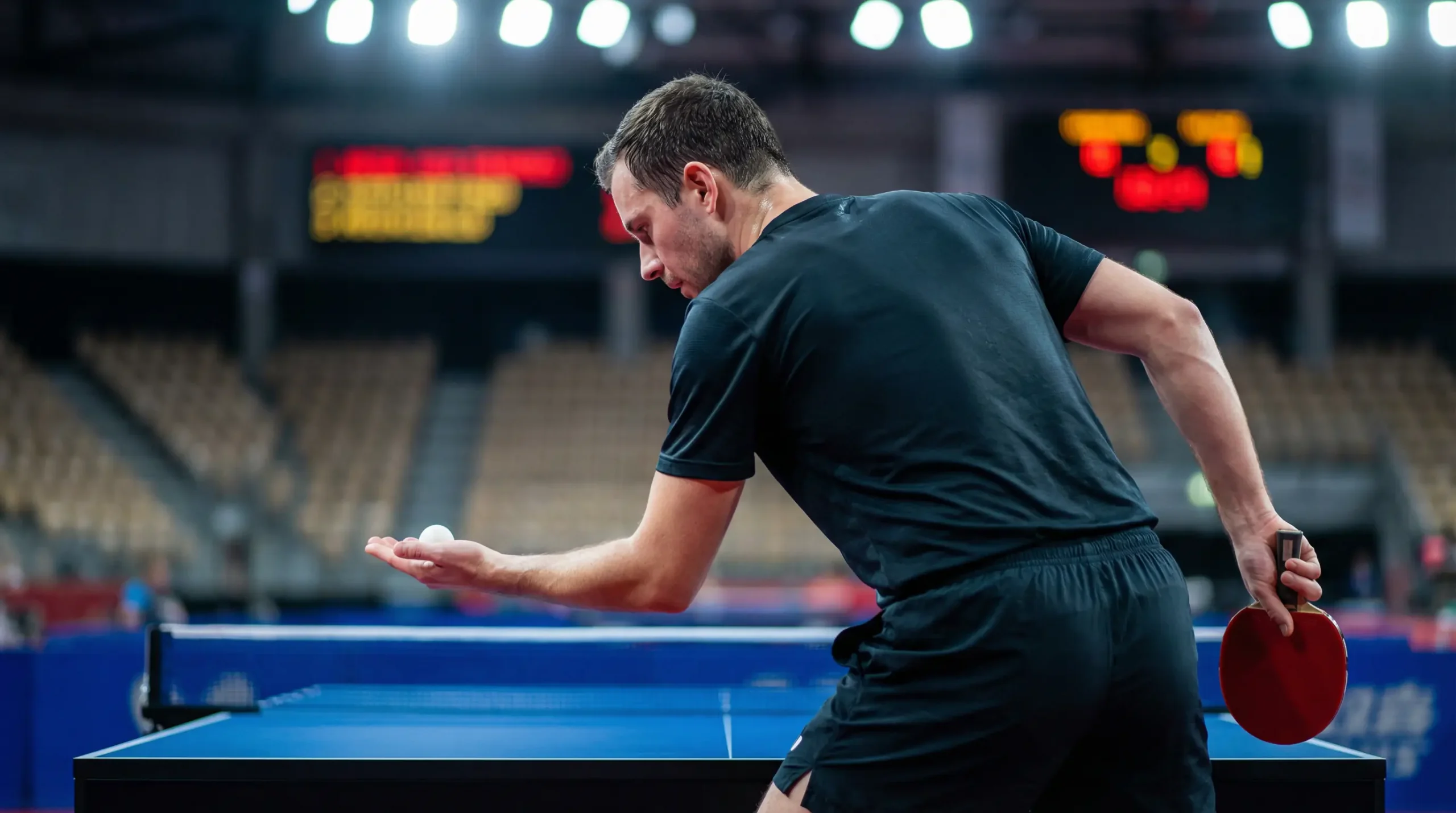 Joueur de tennis de table concentré analysant le jeu de son adversaire avant un service lors d'un tournoi professionnel