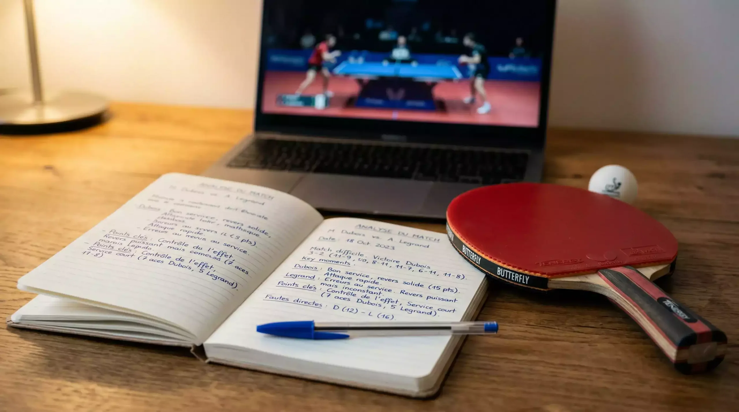 Gros plan sur une raquette de tennis de table posée près d'un carnet de notes d'analyse
